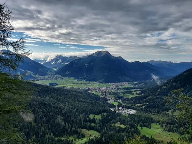 Blick auf Ortschaft inmitten von Bergen und Wäldern