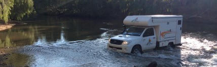 Bush Camper 2 Berth von Tasmania Campers durchquert einen Fluss in Australien