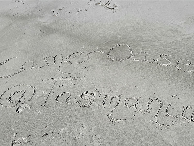Schriftzug im Sand am Strand in Tasmanien