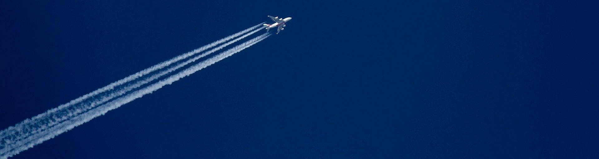 Flugzeug mit Kondensstreifen im Himmel