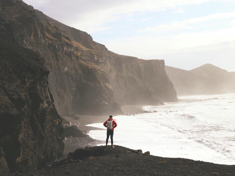 Mann wandert an der isländischen Küste
