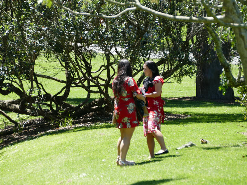 Zwei Frauen in roten Kleidern in einem Park in Auckland 