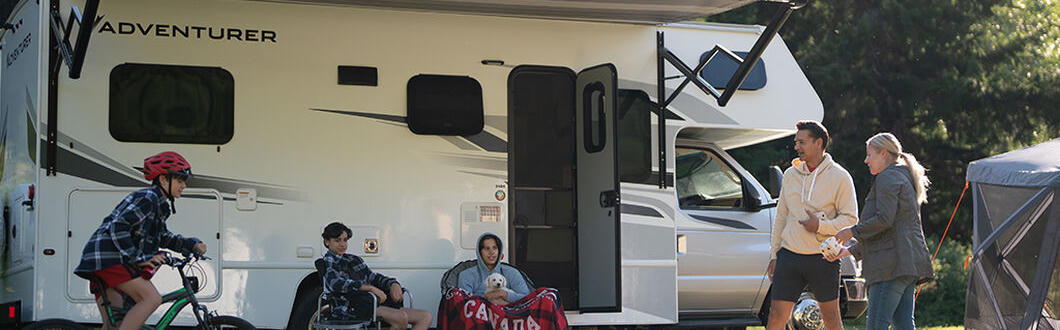 Der Class C Motorhome-Large von Fraserway RV geparkt auf einer Wiese mit einer Familie in Kanada