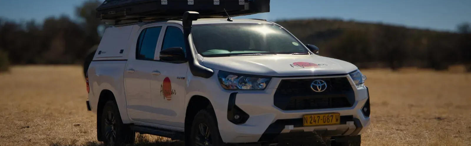 Der Hilux Luxus Camper von AfriCar Car Hire in einer trockenen Landschaft in Namibia