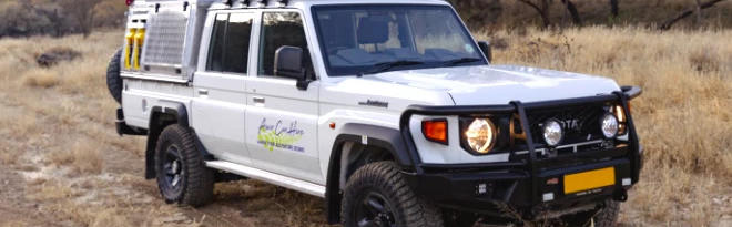 Der Premium Q Landcruiser DC 2.8TD von Asco Car Hire in trockener Landschaft in Namibia