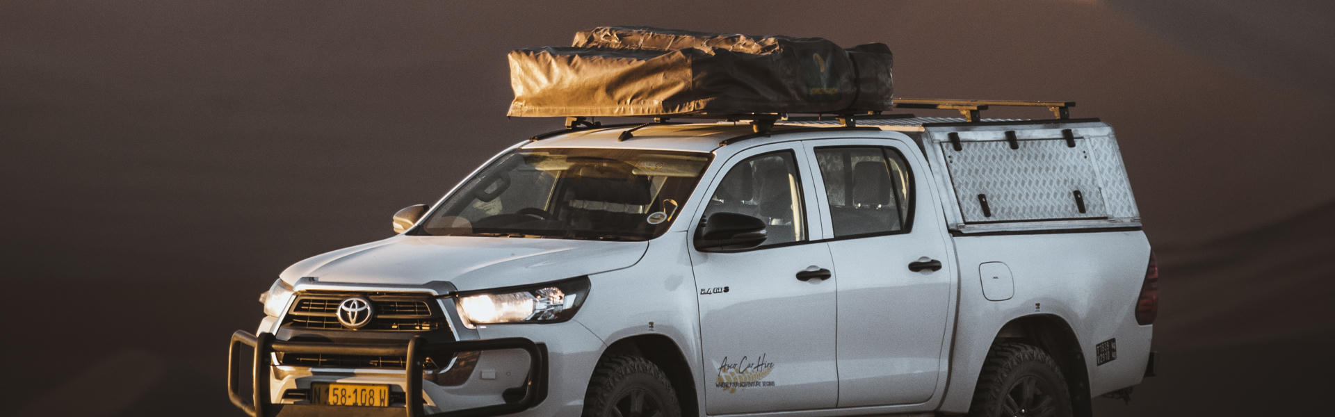 Der Premium S Hilux DC 2.4TD von Asco Car Hire vor einer Sanddüne