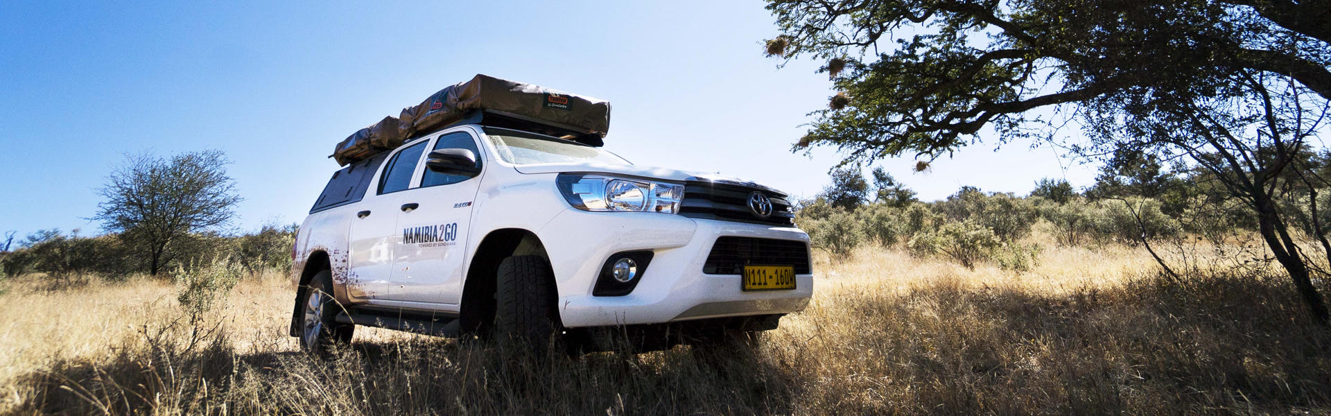 Der 4x4 Toyota Hilux DC Camping von Namibia2Go mit aufgebautem Dachzelt und Campingausstattung in Namibia