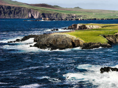 Brandung in Irland entlang des Wild Atlantic Way mit schäumendem Meer und grüner Küste