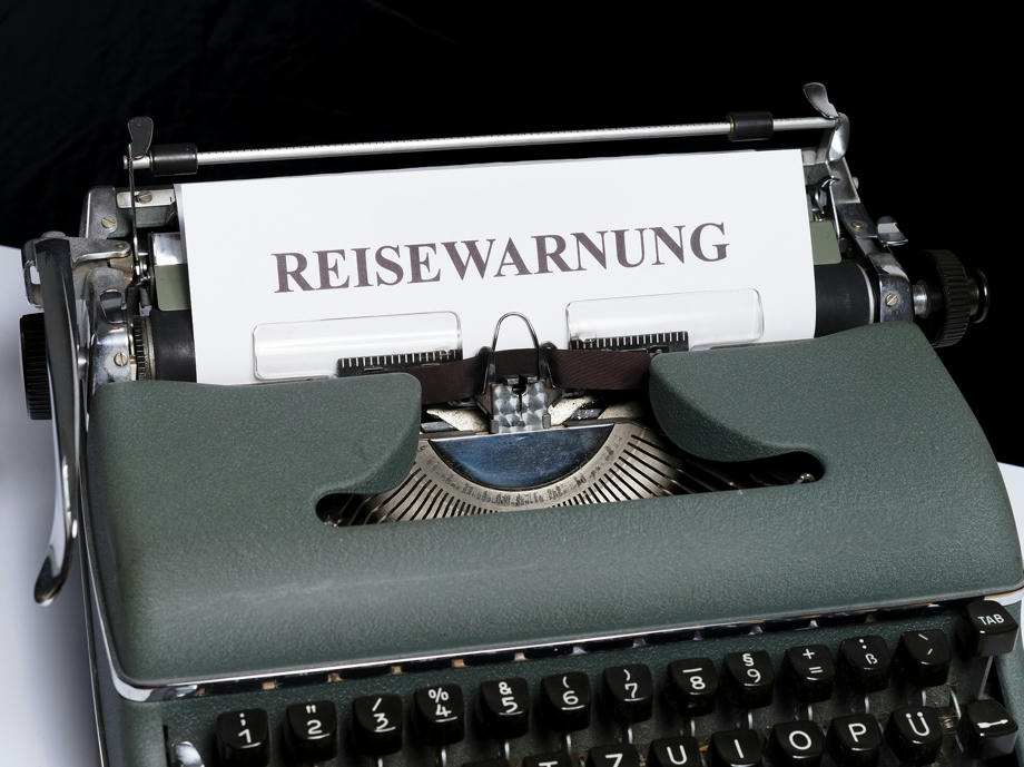 Eine alte Schreibmaschine mit dem Schriftzug Reisewarnung
